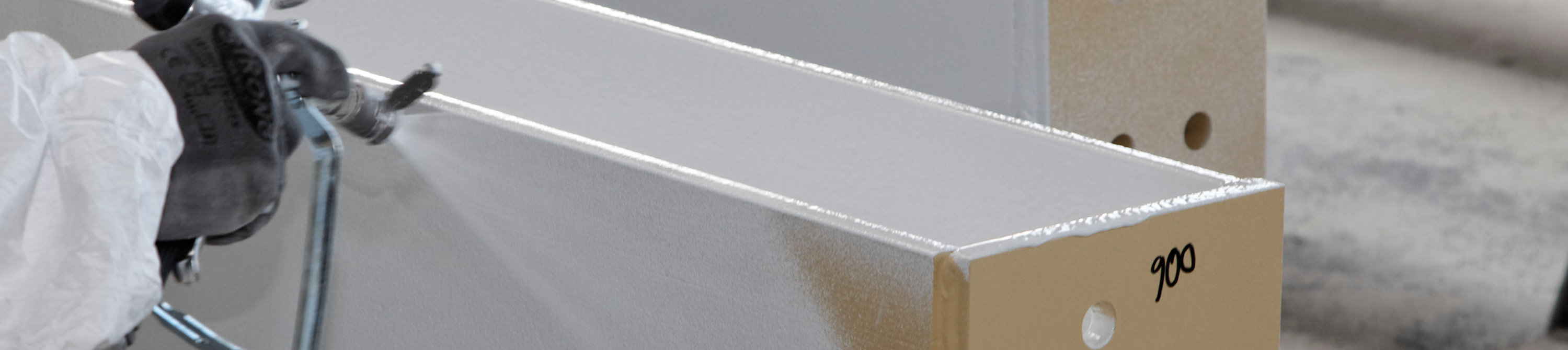 Hand spraying coating on a steel beam 