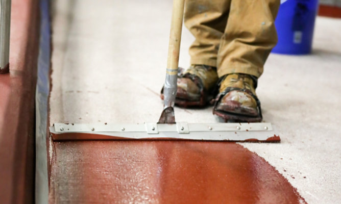 resinous floor being installed using a squeegee