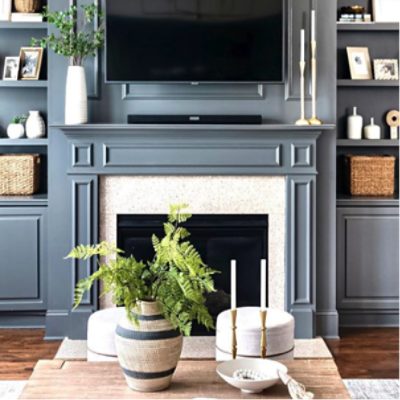 Modern living room painted in forged steel with fireplace, tv, shelves of decor, and coffee table, by @handleyhomeinteriors.