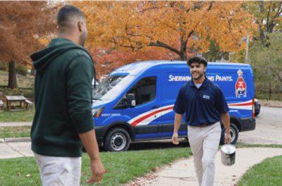 Person with a paint can approaching another person from a Sherwin-Williams truck.