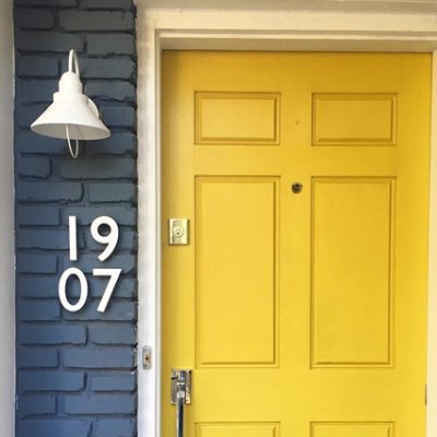 A bright yellow exterior front door. S-W featured color: SW 6697 Nugget. Photo credit @crazygooddesign.