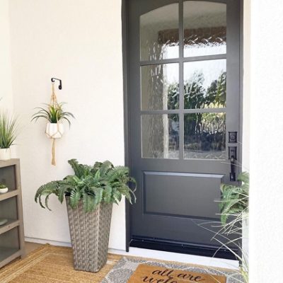 A dark grey and black front door. S-W featured color: SW 7069 Iron Ore. Photo credit @athomewithgray.