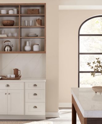 Kitchen walls painted in SW 6099 Sand Dollar with a large window and island.