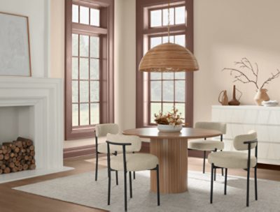 Dining room walls painted in SW 6099 Sand Dollar, fireplace, two windows, round table with four chairs.