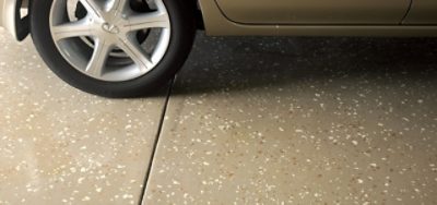 A car parked in a garage with tan flooring