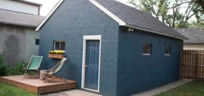 A freshly blue painted garage with white trim and a blue door