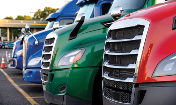 colorful heavy-duty trucks lined up side by side, showcasing industrial vehicle paint finishes