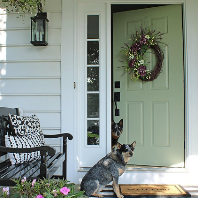 A green front door with two dogs. S-W featured colors: SW 6178, SW 7006.
