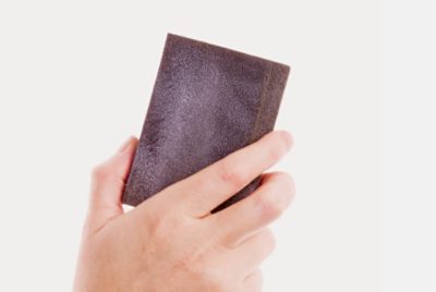 A hand holding a sanding block.