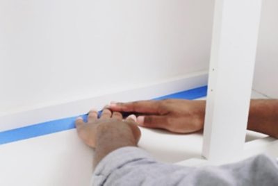 A person applying painter's tape.