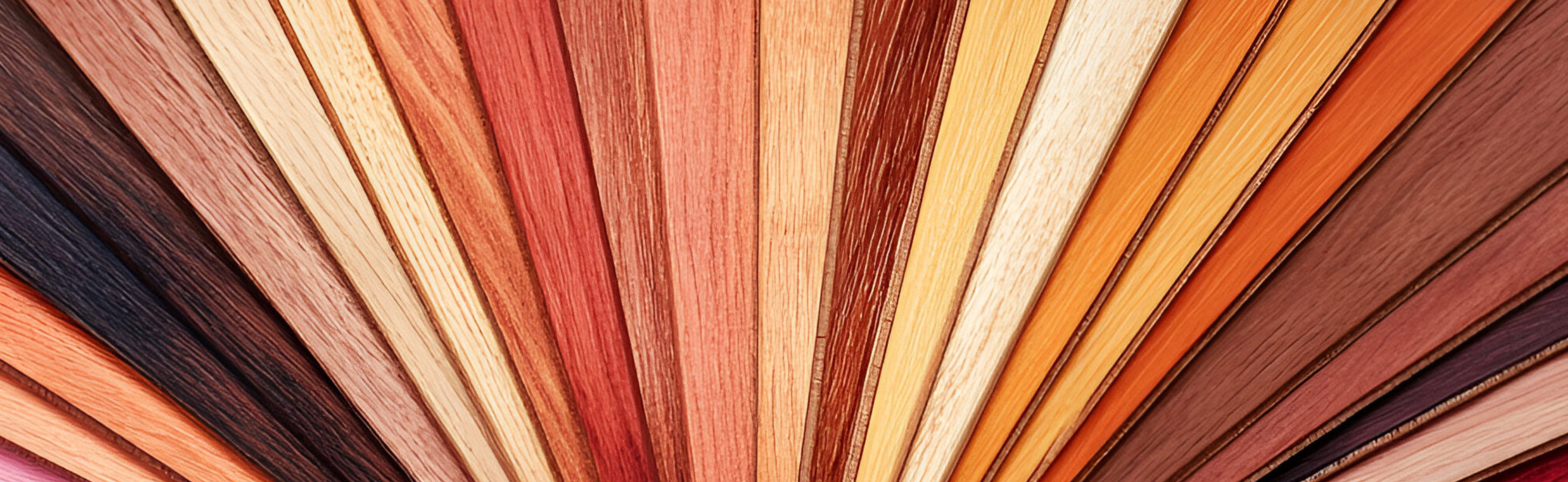 Fan arrangement of wood flooring samples in a wide range of colours and finishes, showcasing design versatility and coating solutions.