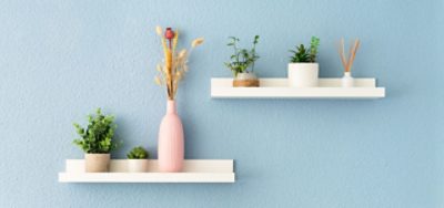 White floating shelves on a robin's egg blue wall.