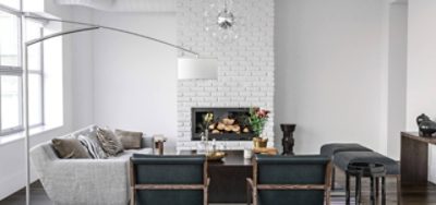A white living room with a white painted brick fireplace.