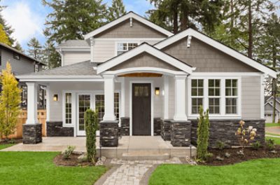 A craftsman-style house with stone work on the lower portion and two shades of tan above.