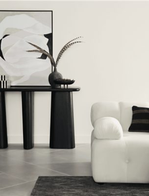 Living area with a white sofa and black table with decorative art.