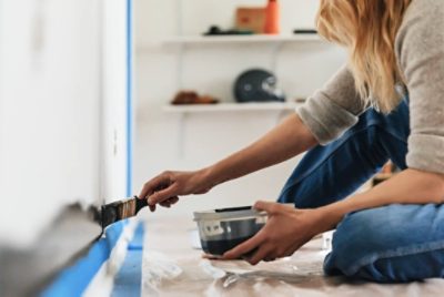 A person cutting in with a brush along the edges of the chalkboard wall.