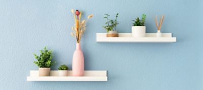 White floating shelves on a robin's egg blue wall.