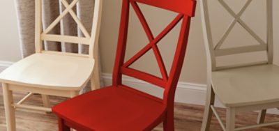 A set of three chairs painted white, red and beige.