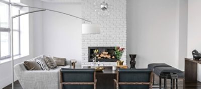 A white living room with a white painted brick fireplace.
