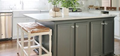 A light gray kitchen island with white cabinetry. 