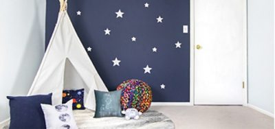 A bedroom with a white tent and blue navy walls with stars.