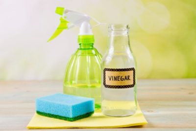 A spray bottle with a vinegar solution and a sponge to remove wallpaper.