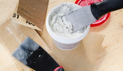 Tools and supplies to repair cracks in a wall.