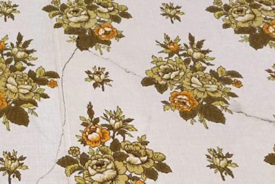 A crack in a wall covered with wallpaper.