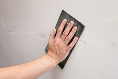 Sanding over a wall crack repair.