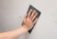 Sanding over a wall crack repair.