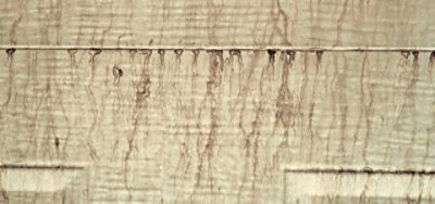 Close-up of a painted surface showing surfactant leaching, with streaks and blotches.