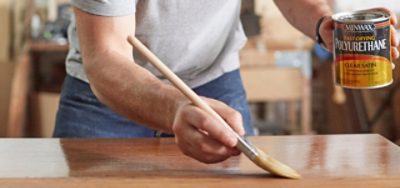 A man staining interior wood. S-W product featured: Fast-Drying Polyutherane.