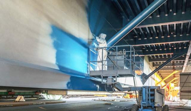 Intermediate coating being applied to concrete