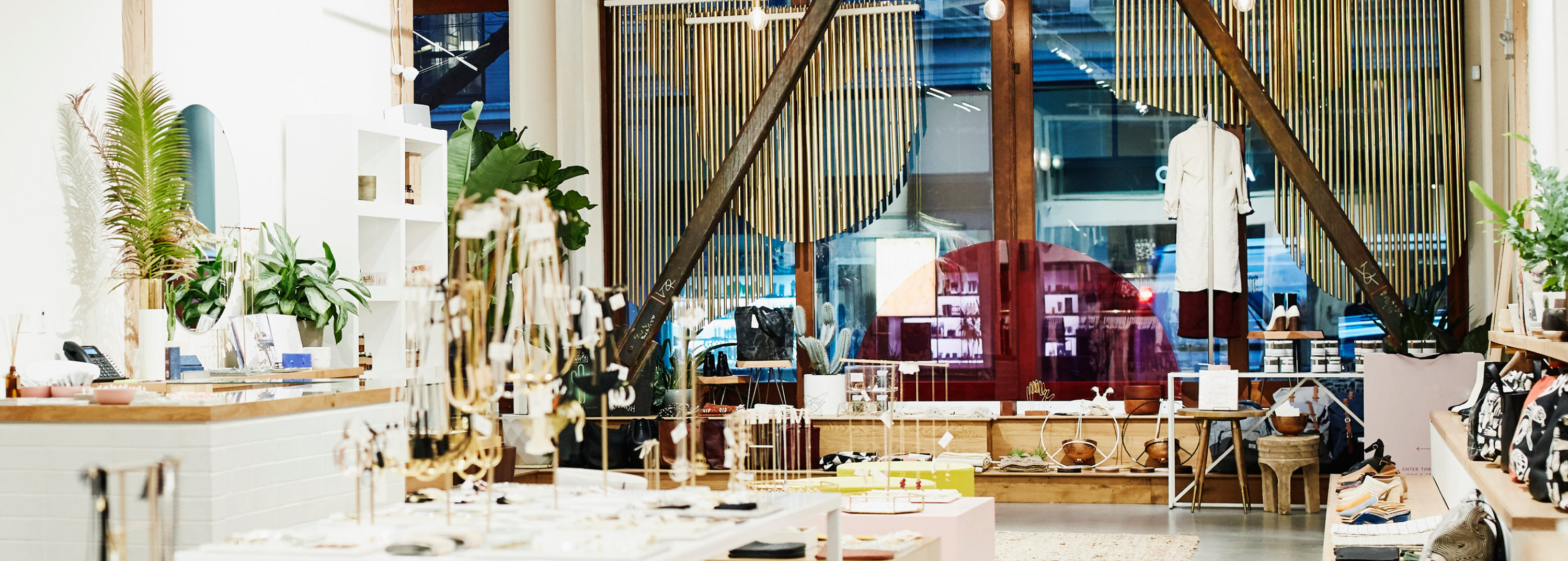 Modern clothing boutique with racks, display tables, and natural light.