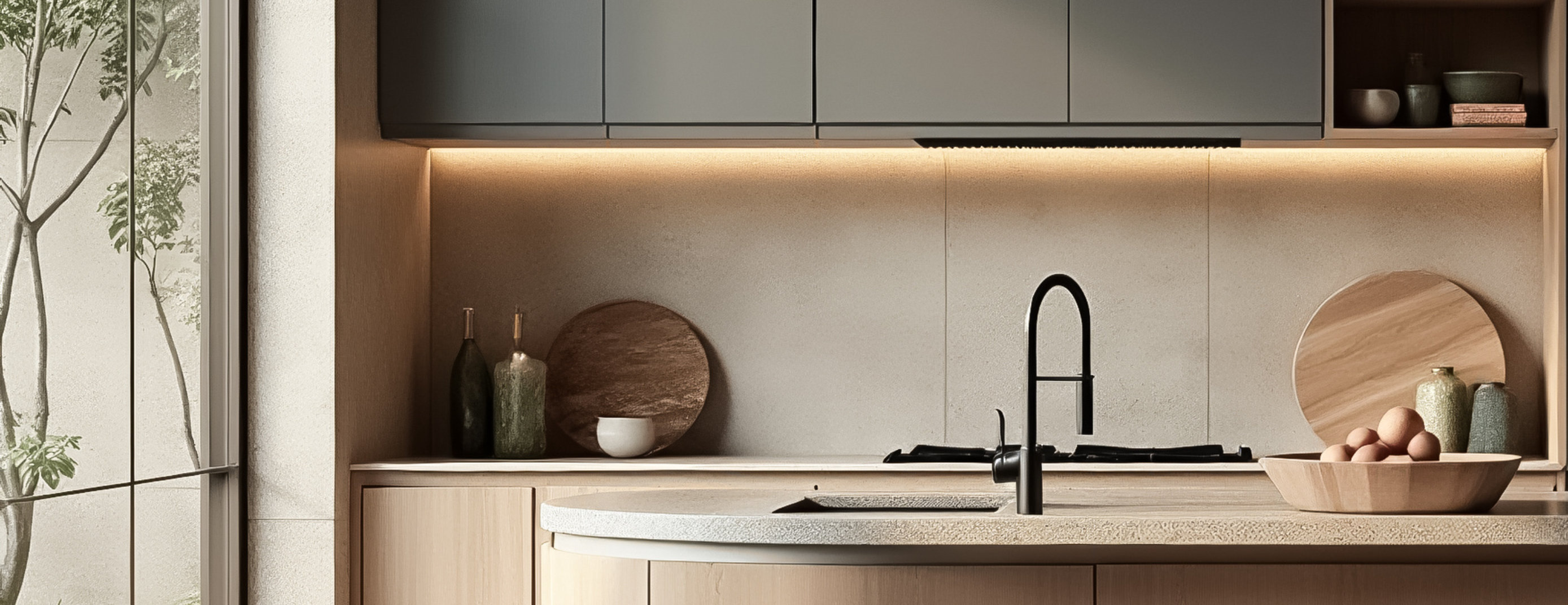 Modern kitchen with central island, wooden bar stools, dark grey cabinetry, and open shelving.