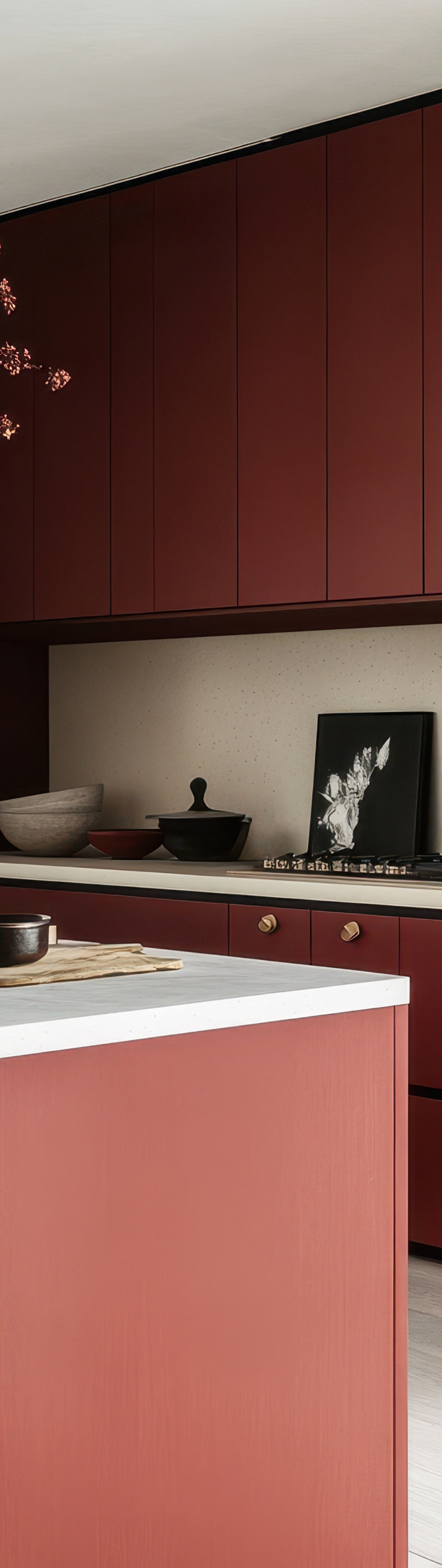 Modern kitchen with red cabinetry, white countertop island, brass faucet, and decorative accents.