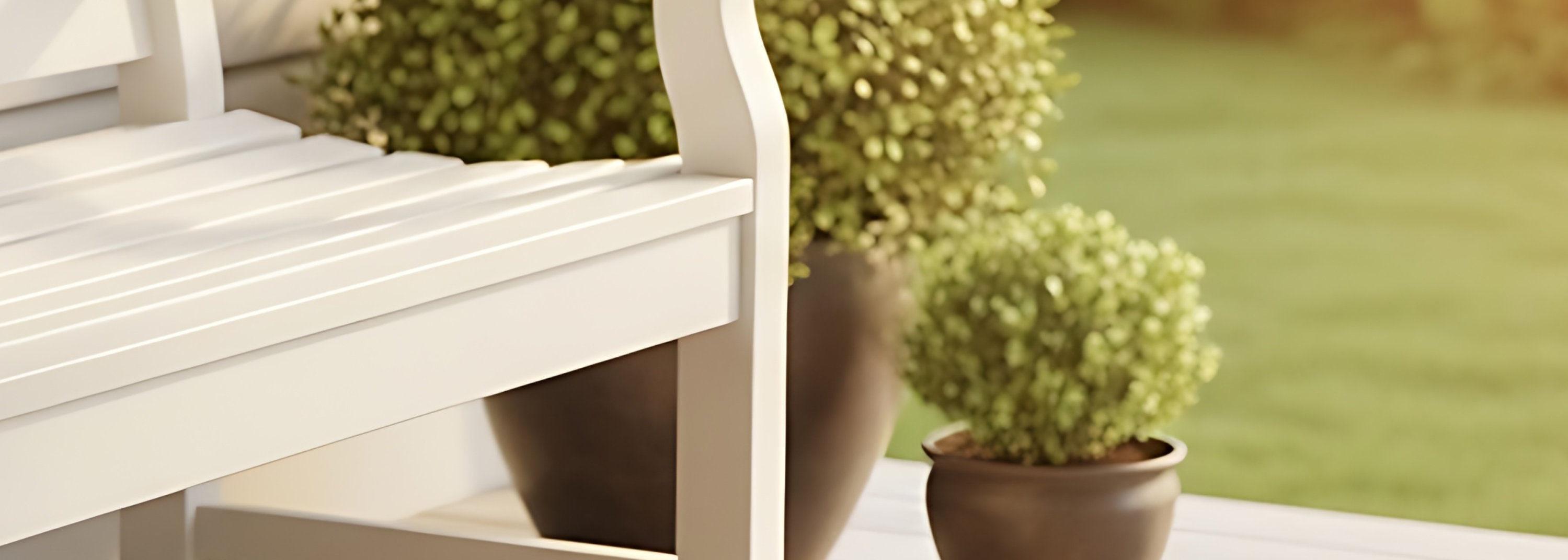 White wooden bench with a black and white checkered pillow, placed on a wooden deck surrounded by potted plants, with a house exterior and sunlit greenery in the background.