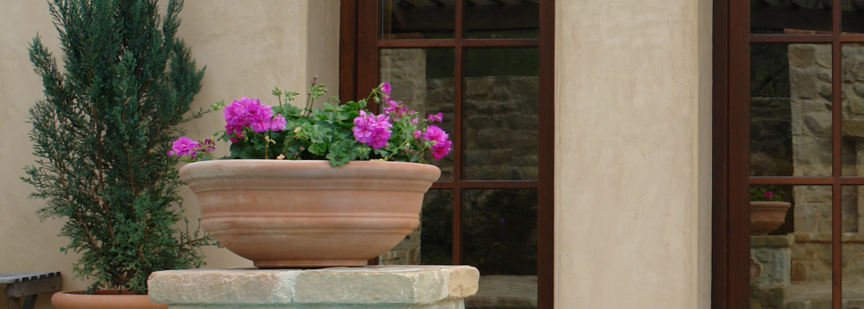 Wooden-framed French doors with glass panes on a beige stucco building, facing a stone patio and pool.