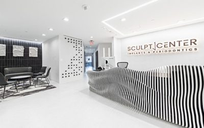 Lobby or reception area of Sculpt Center Implants and Periodontics with white and black color scheme and sculptural, undulating front desk.