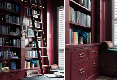 A Sherwin-Williams Burgundy-painted library with bookshelves, a wooden ladder, and a window seat with white shutters.