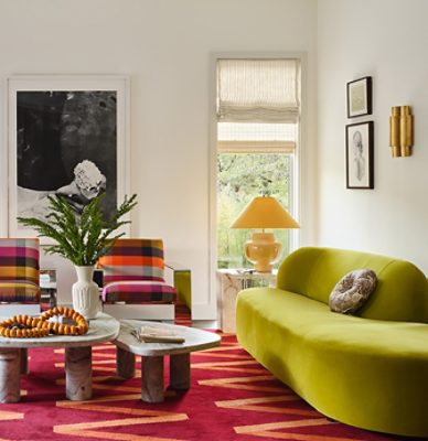 A colorful, modern living room with a lime green sofa, plaid chairs, and a red patterned carpet, featuring eclectic decorations against a backdrop of White Snow painted walls. 