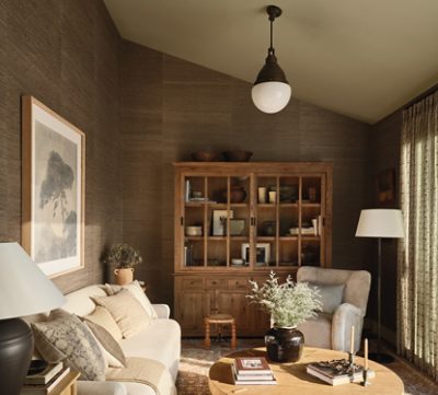 Cozy living room with beige sofa and wooden furniture, featuring earth-toned decor and soft lighting. 
