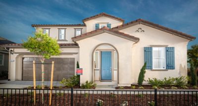 Spanish-style modern home exterior with beige stucco, attached garage, and arched entryway with blue entry door and shutters.