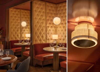 Restaurant interior with red booths, tufted walls, marble tables, and soft lighting. 