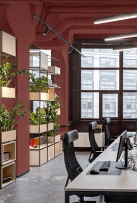 An industrial style conference room with walls and exposed ceiling painted Rookwood Red SW2802.