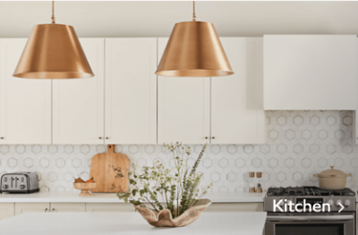 A white  kitchen with a geometric backsplash and two gold pendants over the island.