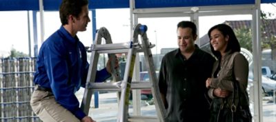 A Sherwin-Williams employee is helping a couple shop for a paint ladder.