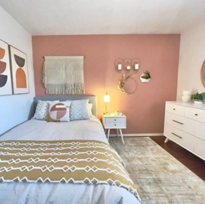 An offwhite dresser cabinet, neutral wall and hanging round mirror. S-W colors featured: SW 0050 Classic Light Buff.