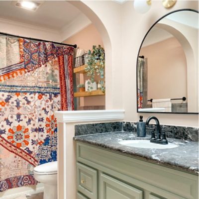 A full bathroom with Sherwin-Williams 2022 color of the year, Evergreen Fog, painted lower cabinets.