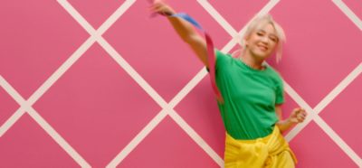 Person dancing in front of a pink wall.
